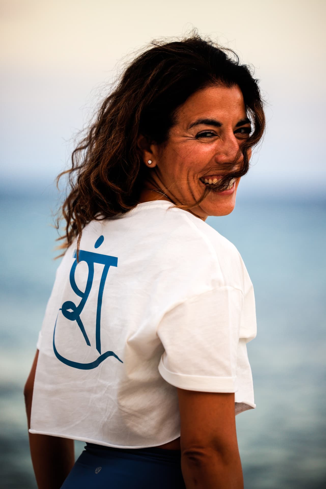 Şelale smiling by the sea, wearing a Seloaktif yoga top